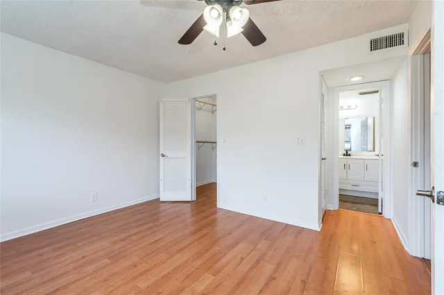 a view of a livingroom with wooden floor and a ceiling fan