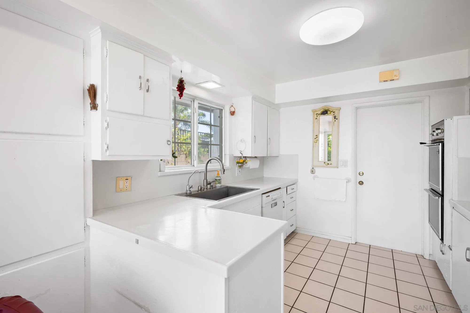 5903 Soledad Mountain Road La Jolla, CA 92037 - Photo 20 of 44 a kitchen with a sink cabinets and window