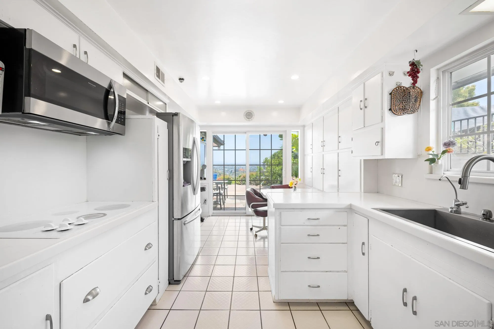 5903 Soledad Mountain Road La Jolla, CA 92037 - Photo 22 of 44 a kitchen with a sink window and stainless steel appliances