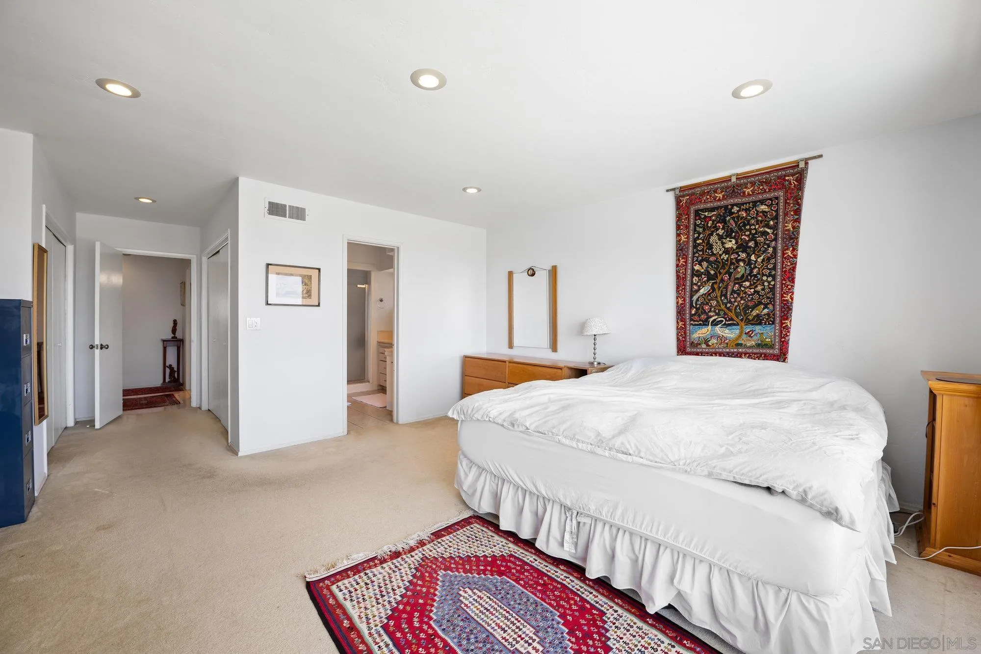 5903 Soledad Mountain Road La Jolla, CA 92037 - Photo 24 of 44 a spacious bedroom with a bed and a lamp
