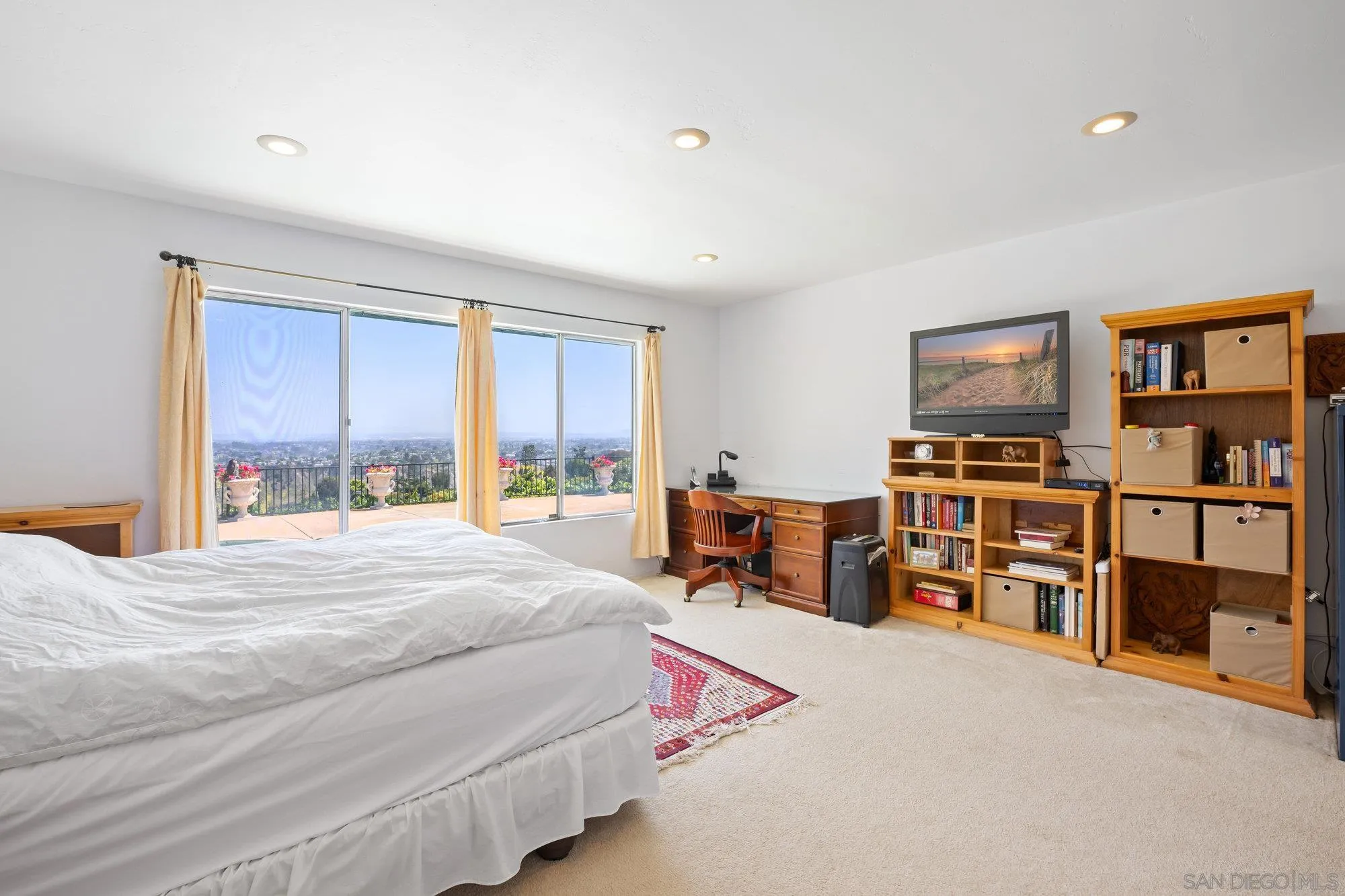 5903 Soledad Mountain Road La Jolla, CA 92037 - Photo 25 of 44 a bedroom with a bed a large window and book shelf