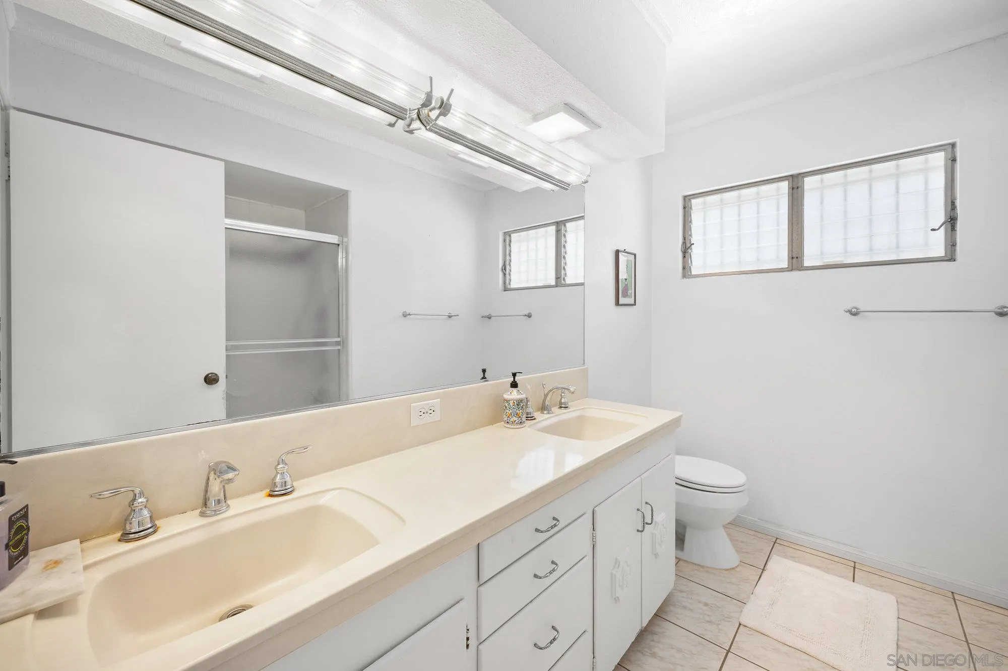 5903 Soledad Mountain Road La Jolla, CA 92037 - Photo 27 of 44 a bathroom with a double vanity sink toilet and a mirror