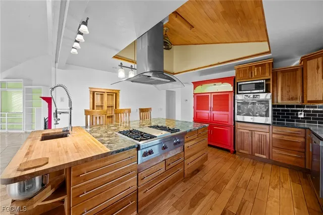 a kitchen that has a stove and a wooden floor