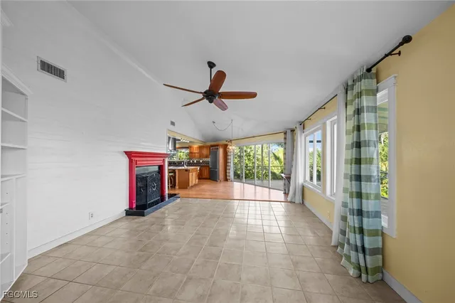 a view of empty room with floor to ceiling window and ceiling fan