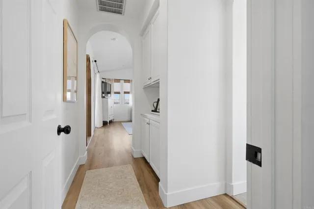 a view of a hallway with wooden floor and closet