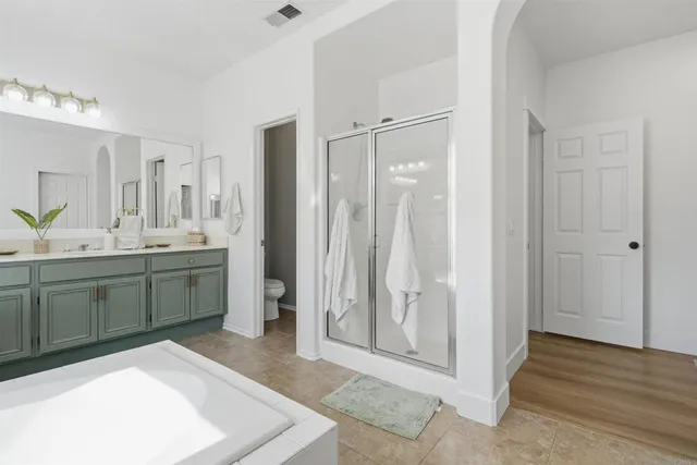 a spacious bathroom with a shower sink and mirror
