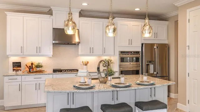 a kitchen with stainless steel appliances kitchen island granite countertop a sink and cabinets