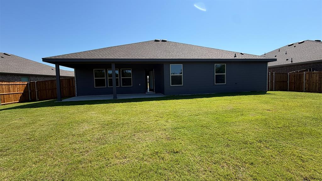 1913 Reveille Way Terrell, TX 75160 - Photo 26 of 35 Expansive green lawn with a covered patio, multiple windows, and a privacy fence
