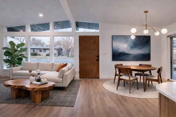 a living room with furniture a dining table and a flat screen tv