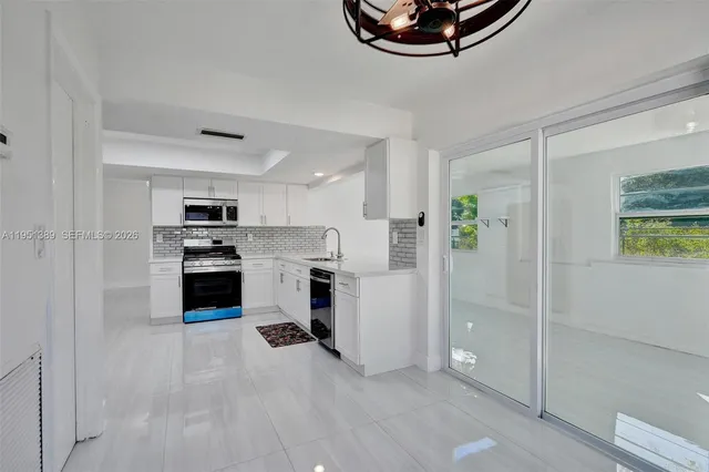 a kitchen with white cabinets and stainless steel appliances