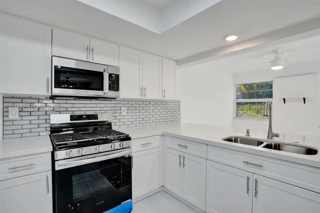 a kitchen with cabinets stainless steel appliances and a counter space