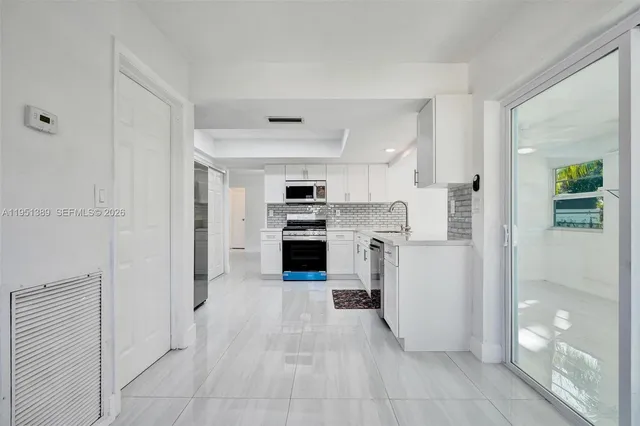 a view of a kitchen with a sink and a refrigerator