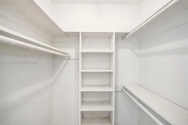 a view of walk in closet with empty racks