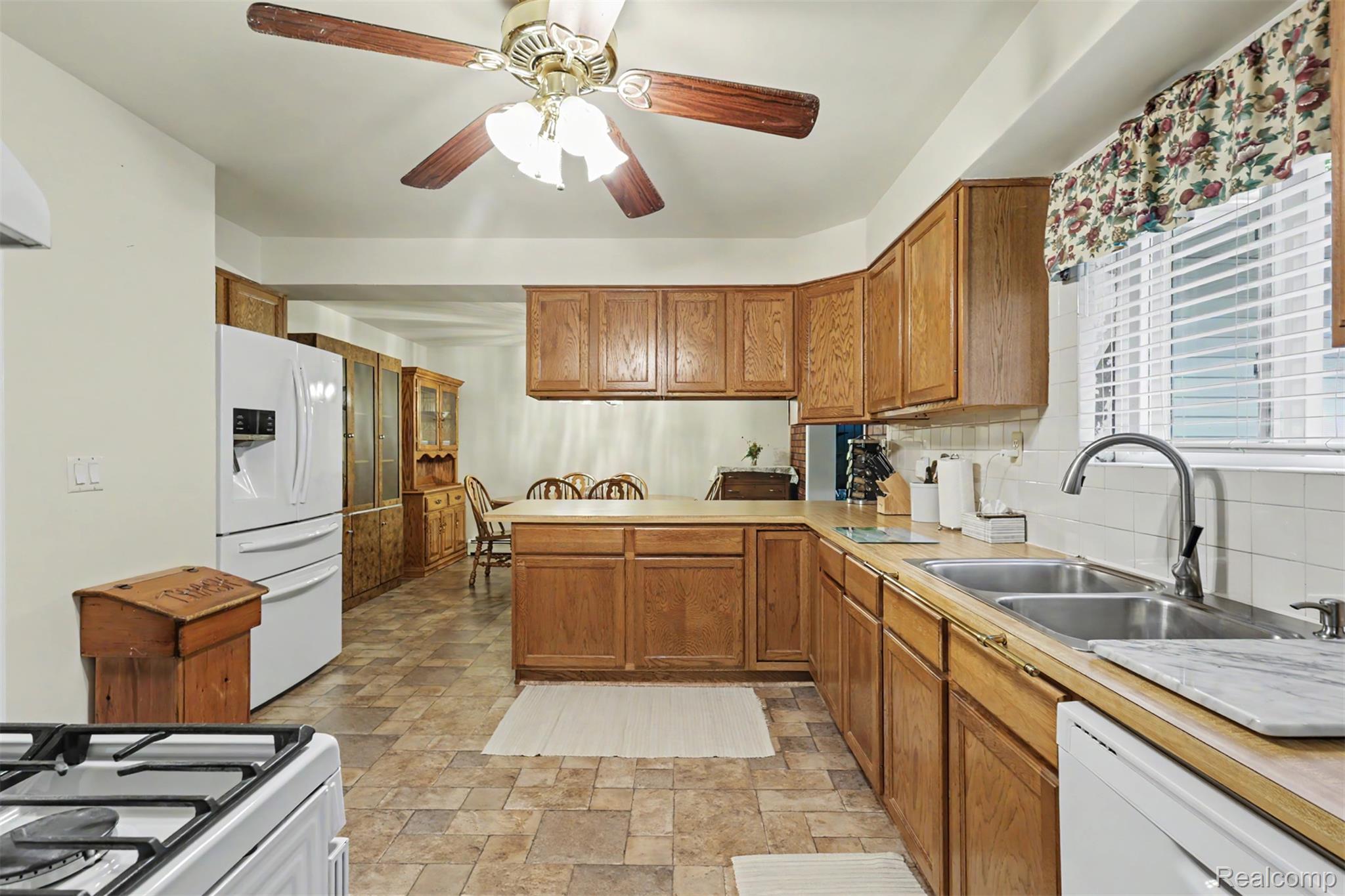 45223 Wear Road Belleville, MI 48111 - Photo 14 of 60 Kitchen featuring wood cabinetry, laminate countertops, a dual basin stainless steel sink, and a multi-speed ceiling fan