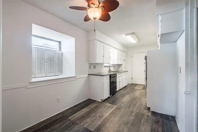 a kitchen with stainless steel appliances granite countertop a refrigerator a sink dishwasher a stove and white countertops with wooden floor