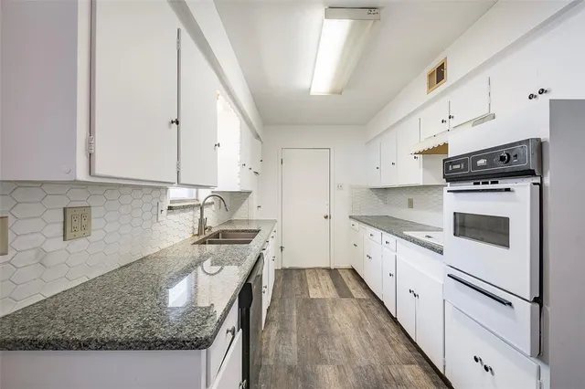 a kitchen with granite countertop white cabinets and white appliances