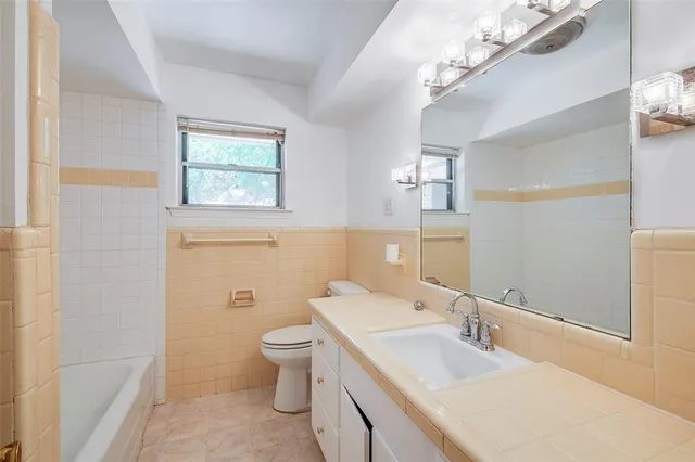 a bathroom with a double vanity sink toilet and a mirror