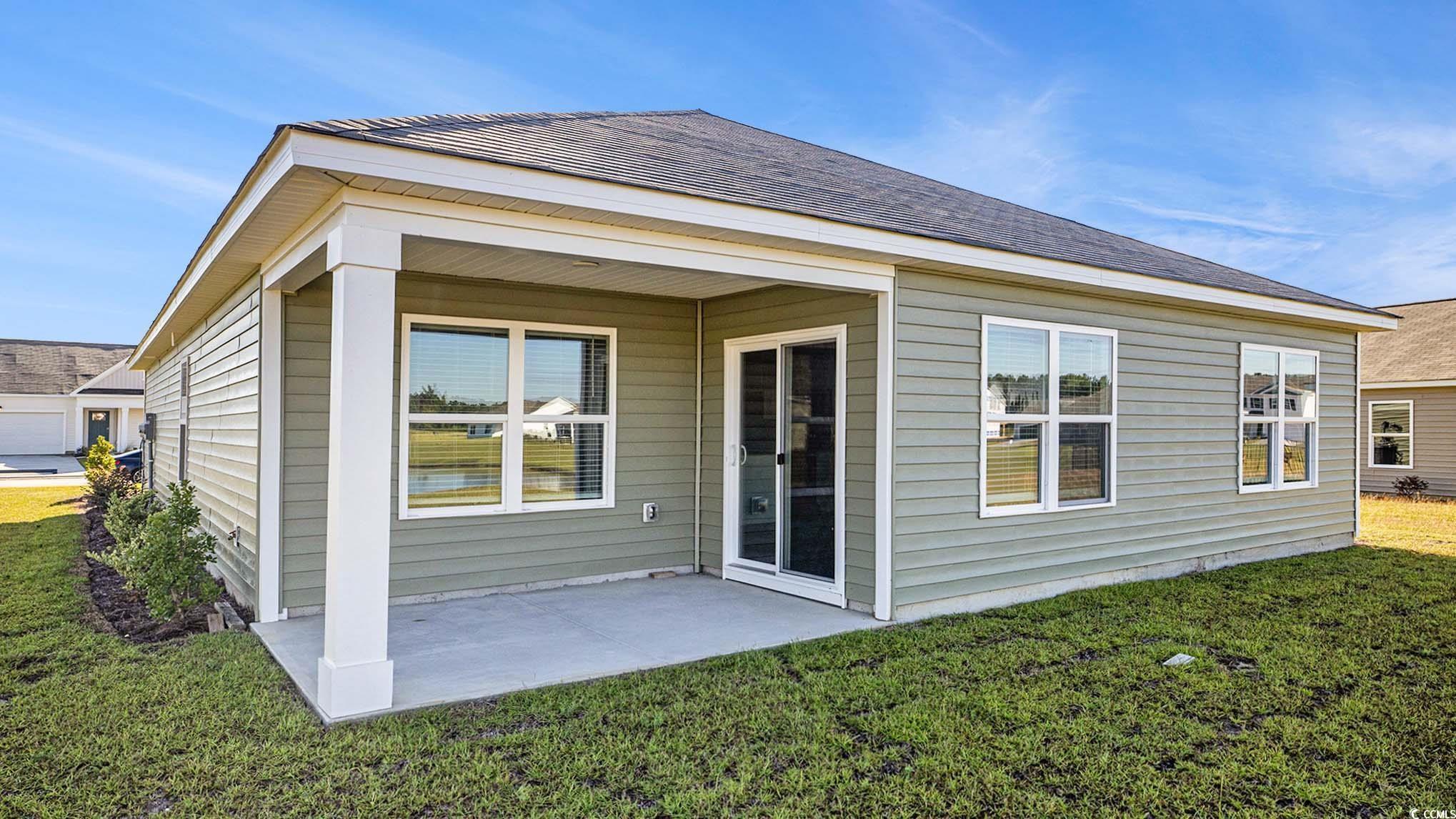 109 Homestead Way Myrtle Beach, SC 29588 - Photo 2 of 22 Rear view of house with a yard and a patio