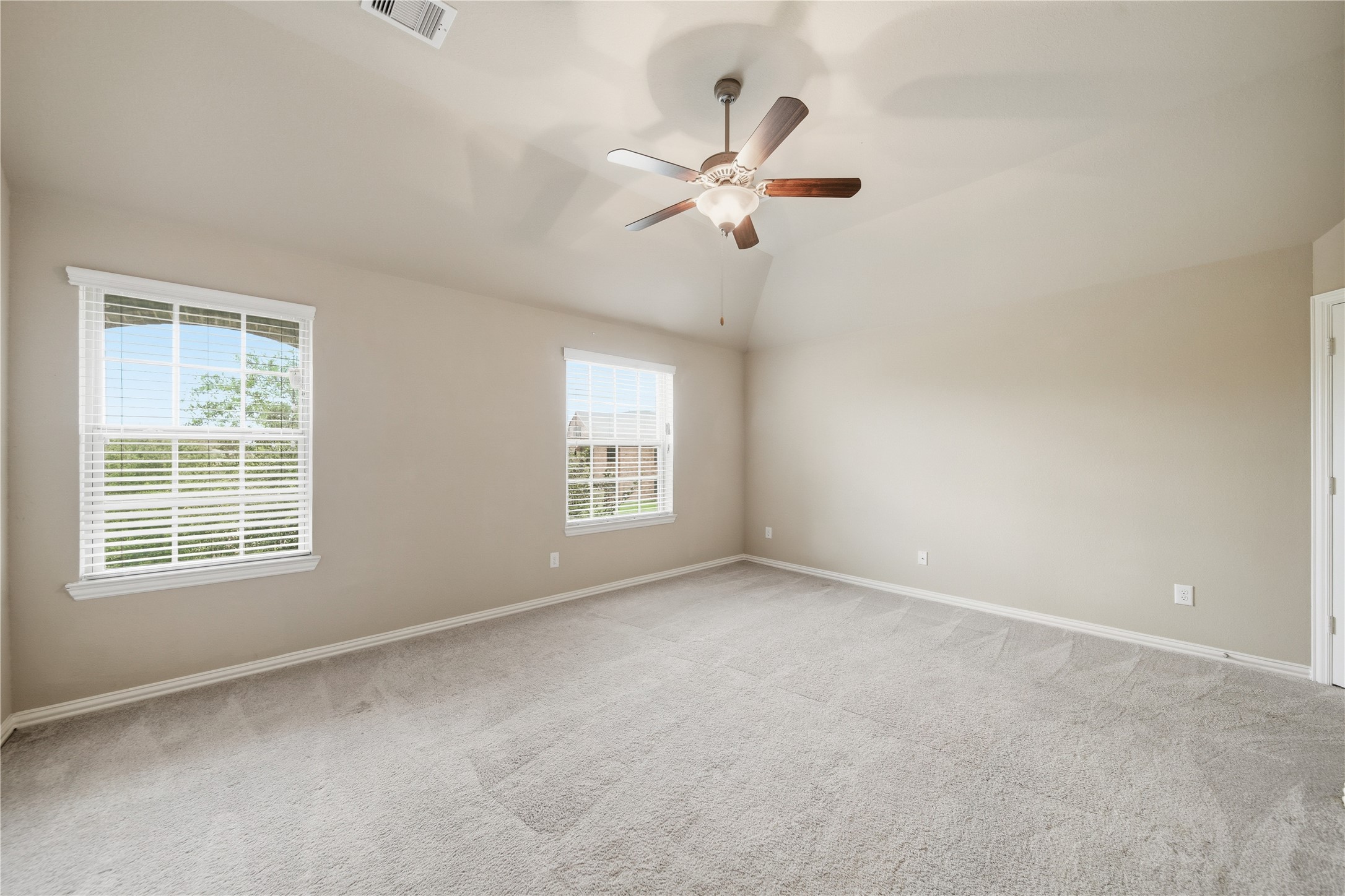 5303 Mesquite Willow Lane Rosharon, TX 77583 - Photo 28 of 32 This spacious bedroom features soft carpet, neutral walls, two large windows for natural light, and a ceiling fan for comfort.