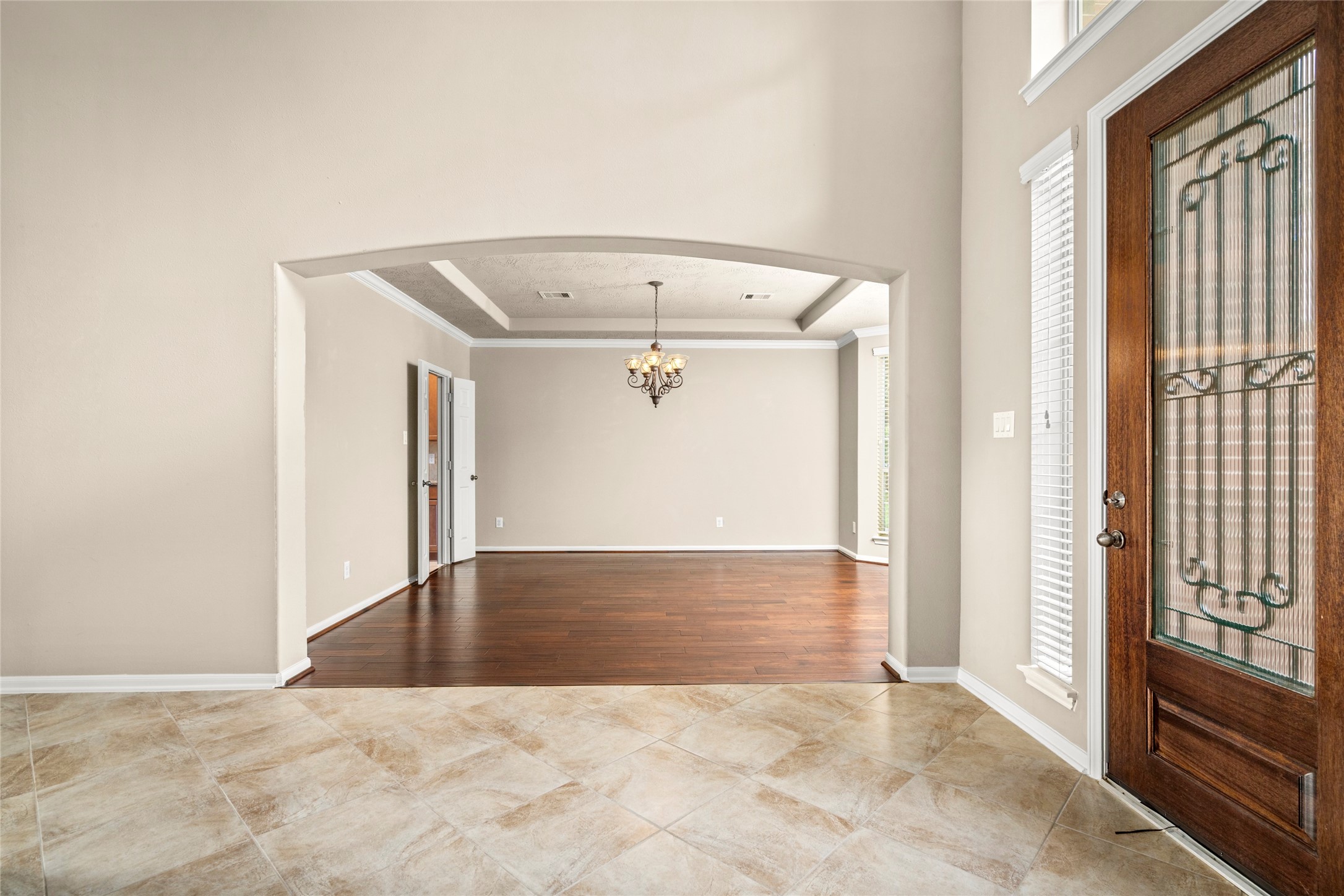 5307 Amber Sky Lane Rosharon, TX 77583 - Photo 9 of 50 Rich wood flooring, a statement chandelier, and an elegant glass-paneled front door set the tone here, opening gracefully into the formal dining room, designed for unforgettable entertaining.