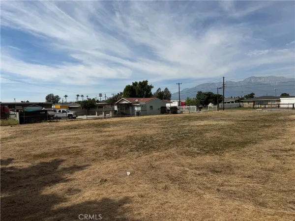 a view of a white house with a yard and potted plants