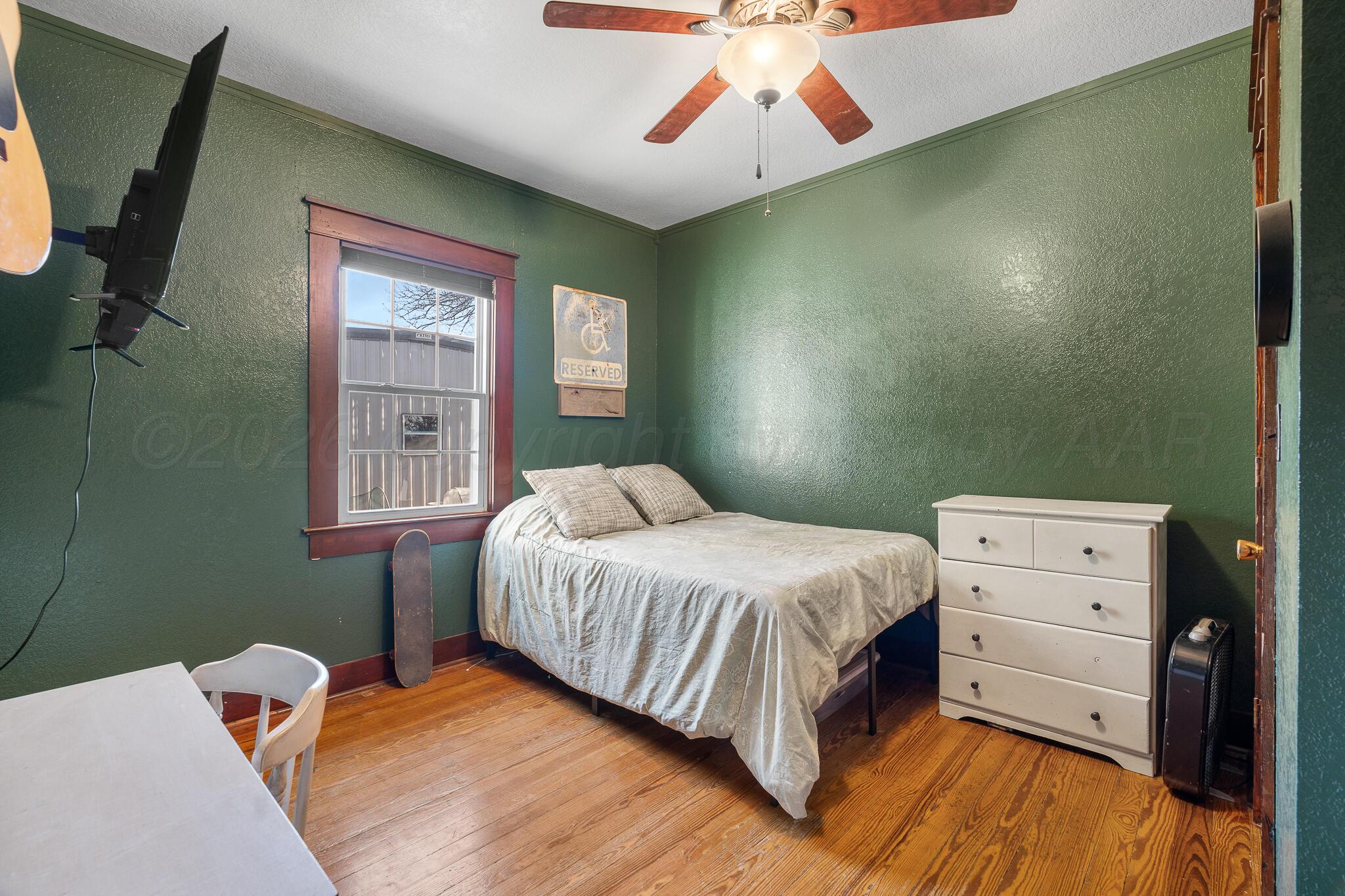 1401 3rd Avenue Canyon, TX 79015 - Photo 11 of 40 a bedroom with a bed and a chandelier