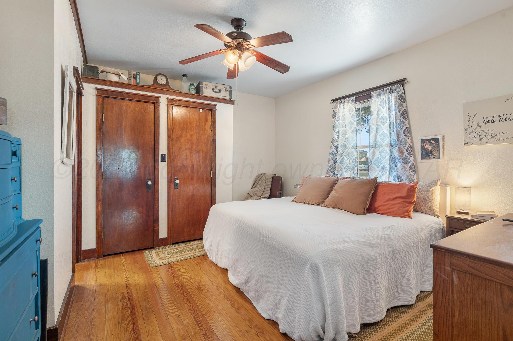 1401 3rd Avenue Canyon, TX 79015 - Photo 12 of 40 a bedroom with a large bed and a chandelier