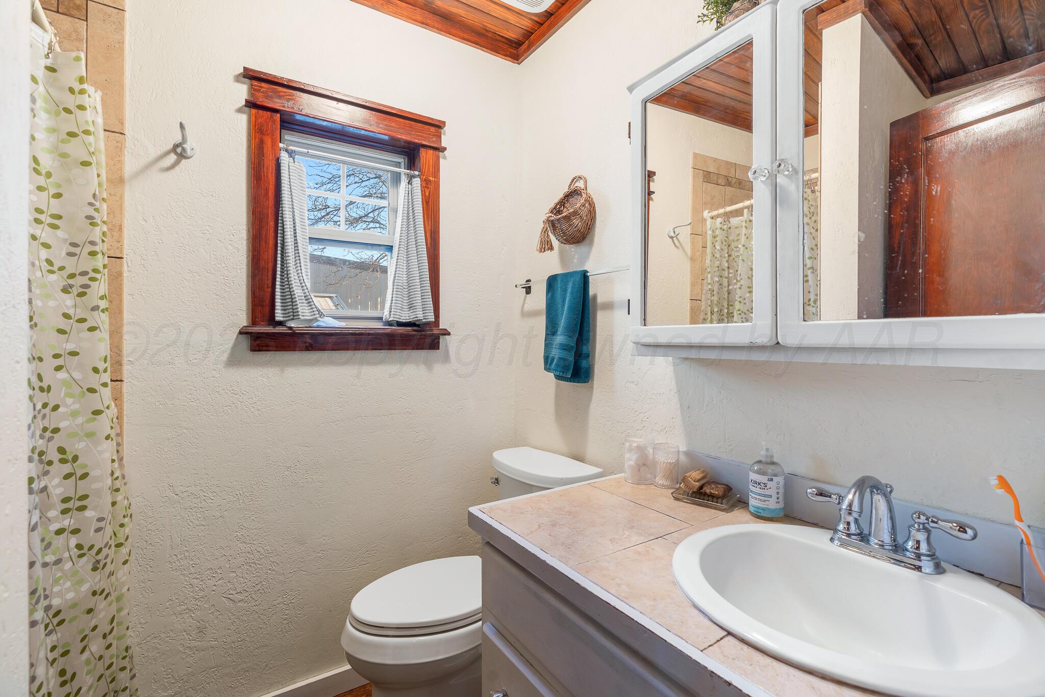 1401 3rd Avenue Canyon, TX 79015 - Photo 14 of 40 a bathroom with a toilet sink and mirror