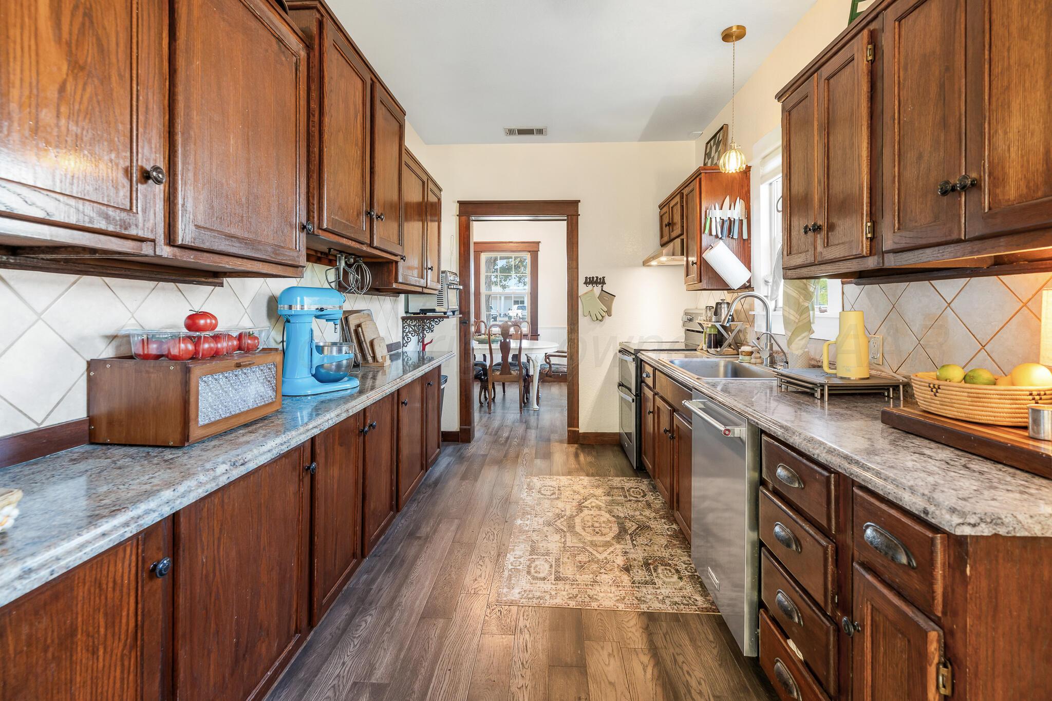 1401 3rd Avenue Canyon, TX 79015 - Photo 17 of 40 a kitchen with stainless steel appliances granite countertop a sink stove and cabinets