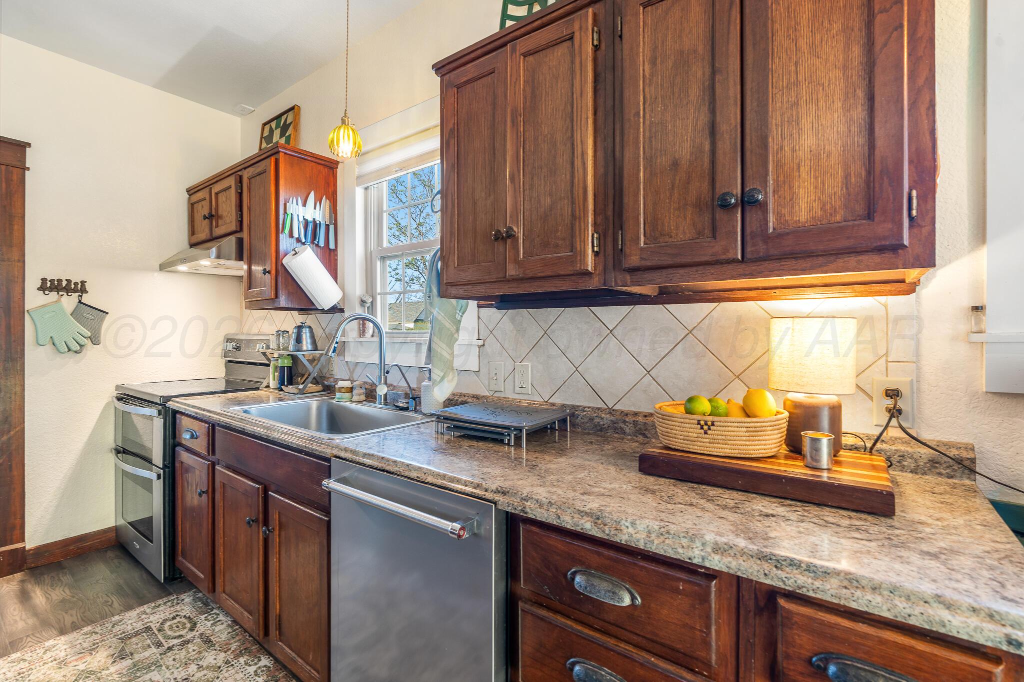 1401 3rd Avenue Canyon, TX 79015 - Photo 18 of 40 a kitchen with granite countertop stainless steel appliances a sink and a counter top space