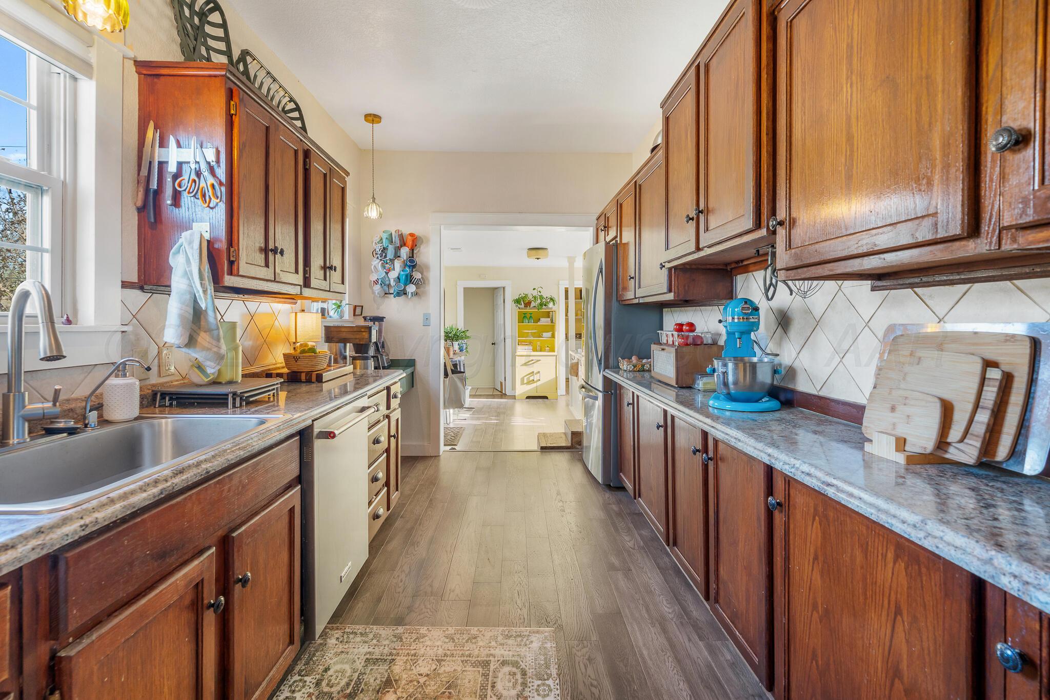1401 3rd Avenue Canyon, TX 79015 - Photo 21 of 40 a kitchen with stainless steel appliances granite countertop a sink and cabinets