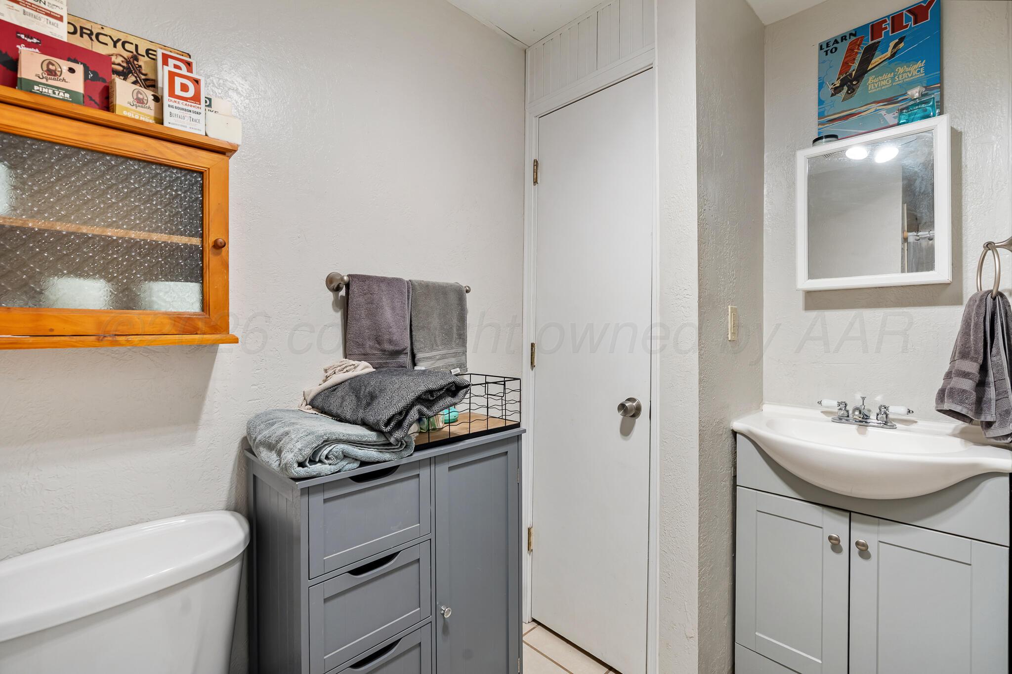 1401 3rd Avenue Canyon, TX 79015 - Photo 25 of 40 a bathroom with a sink a toilet and mirror