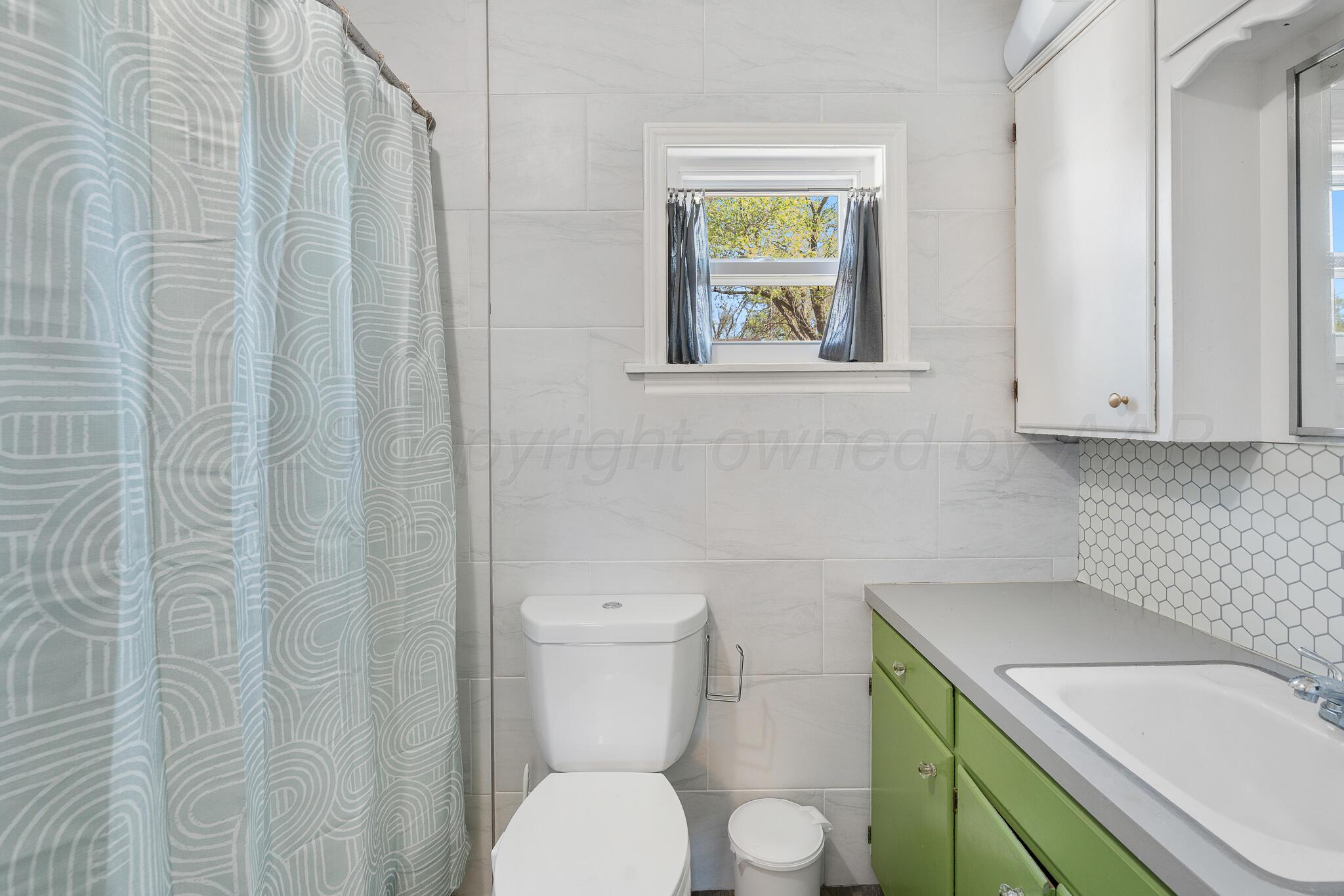 1401 3rd Avenue Canyon, TX 79015 - Photo 39 of 40 a bathroom with a sink a toilet and a window