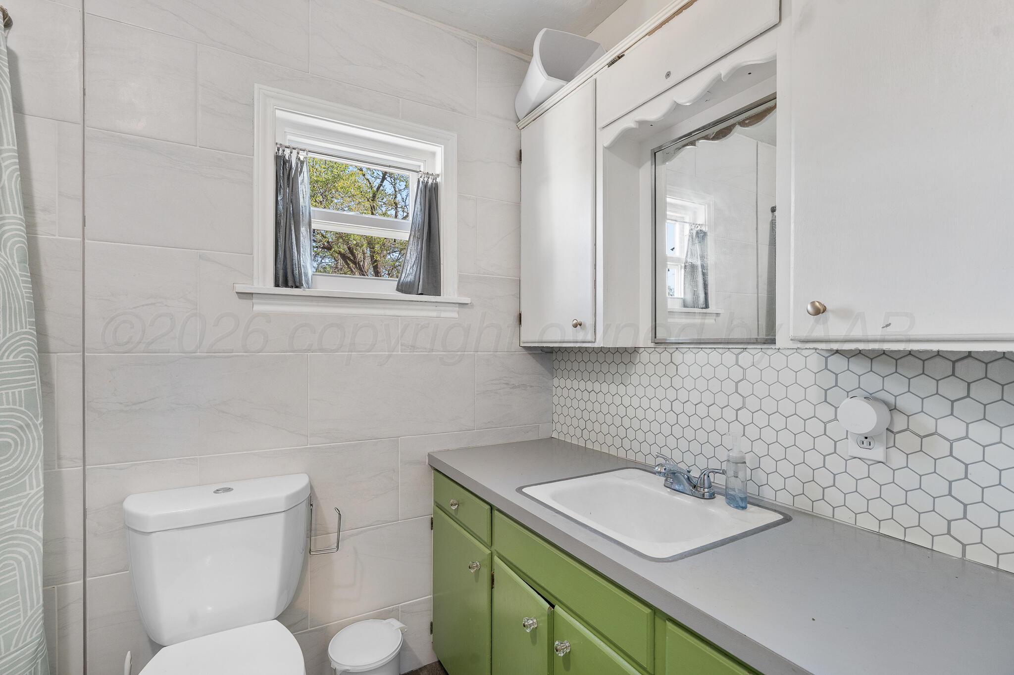 1401 3rd Avenue Canyon, TX 79015 - Photo 40 of 40 a bathroom with a sink a toilet and a window