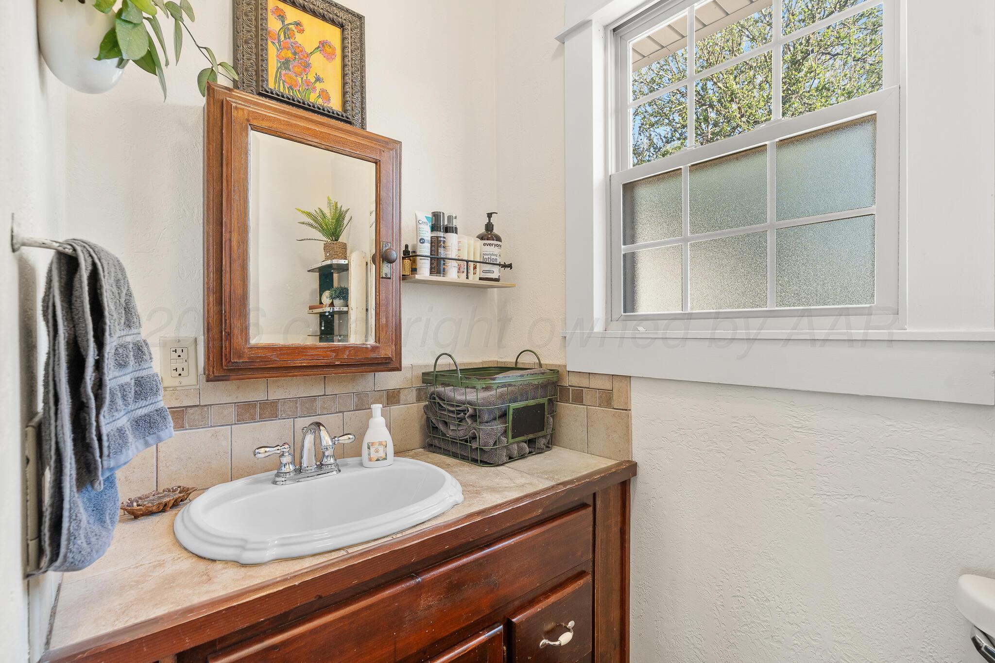 1401 3rd Avenue Canyon, TX 79015 - Photo 10 of 40 a bathroom with a sink a toilet and a mirror