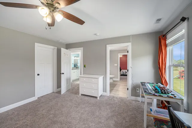 a furnished livingroom with a window and workspace