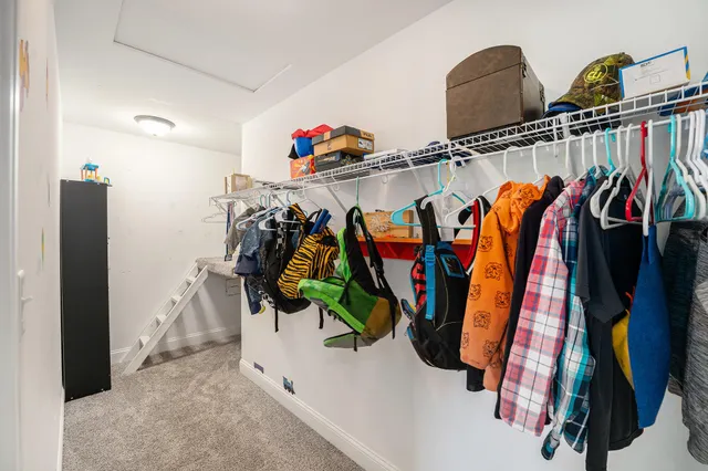 a view of walk in closet with clothes and shoes