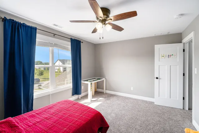 a bedroom with a bed and a large window