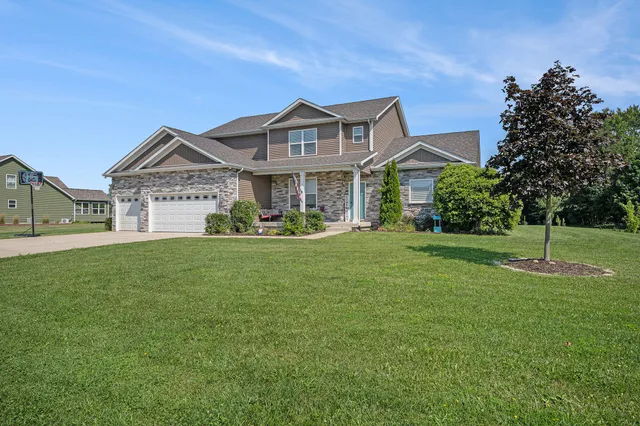 a front view of a house with a garden and plants