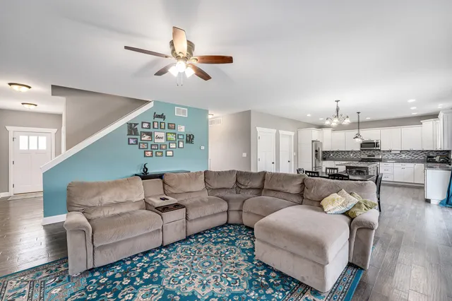 a living room with furniture kitchen view and a chandelier