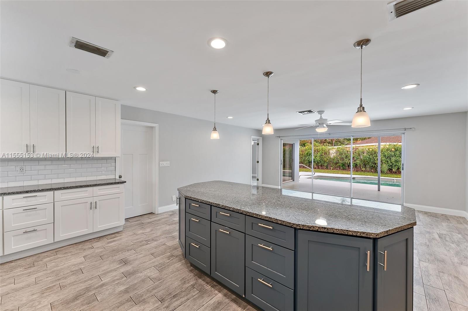 538 Dover Road Tequesta, FL 33469 - Photo 15 of 63 a kitchen with kitchen island granite countertop a stove a sink a counter space and a center island