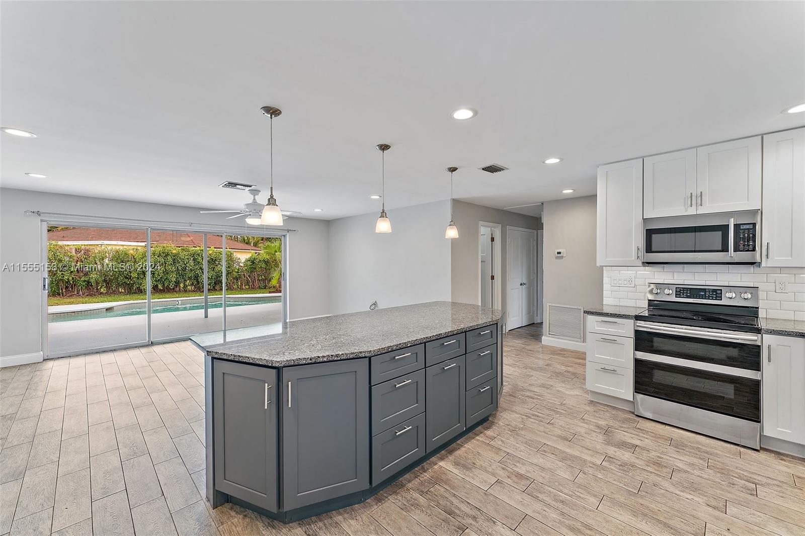 538 Dover Road Tequesta, FL 33469 - Photo 16 of 63 a kitchen with stainless steel appliances granite countertop a stove and a wooden floors