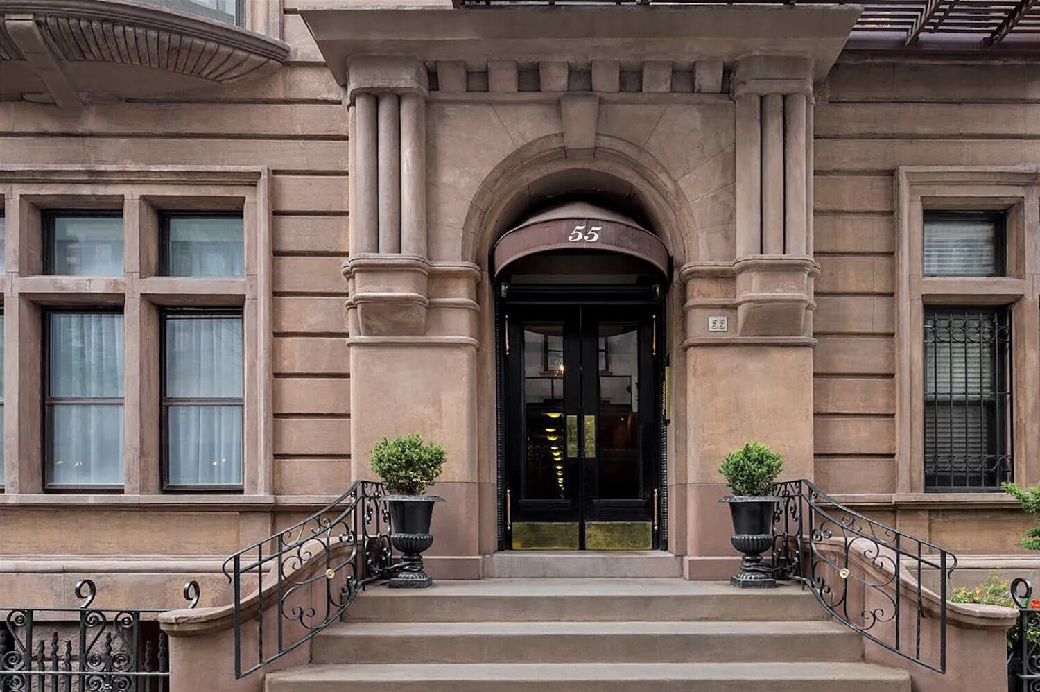 55 East 65th Street, Unit 7A Manhattan, NY 10065 - Photo 17 of 18 a front view of a house with potted plants