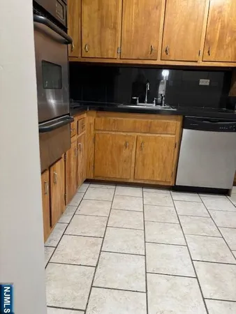 a kitchen with stainless steel appliances a sink a stove a microwave and cabinets