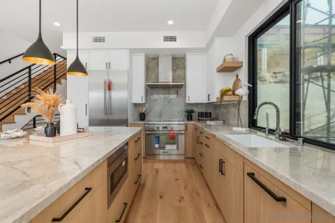 a kitchen with stainless steel appliances granite countertop a sink and a stove