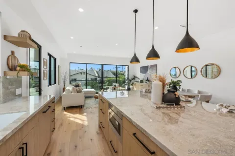 a kitchen with sink and view of living room