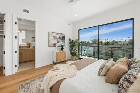 a bedroom with a bed and a large window