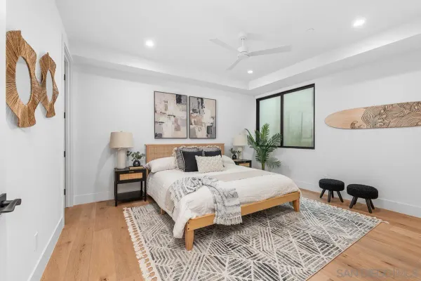 a bedroom with a large bed a rug and a wooden floor