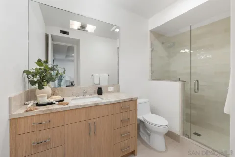 a bathroom with a sink a toilet and shower