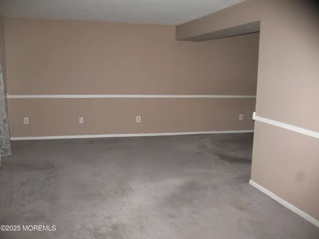 en empty room with window and chandelier fan